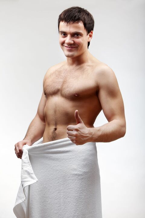 the man in a towel is satisfied with the increased size of his penis